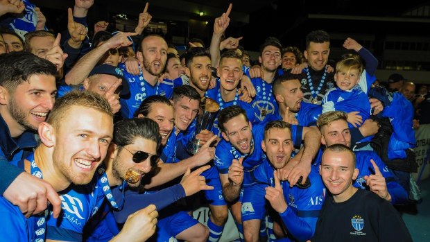 All smiles: South Melbourne players and fans celebrate after lifting another state league trophy.