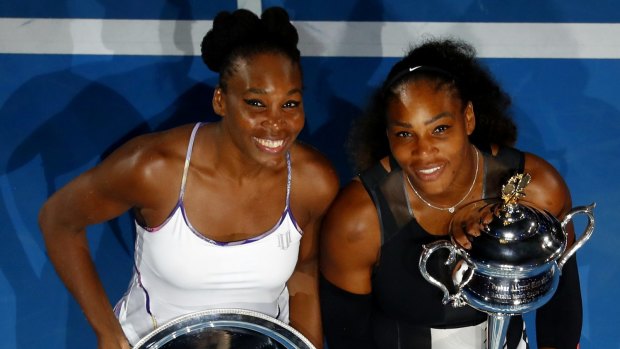 Sister act ... Venus (left) and Serena Williams pose with their trophies.