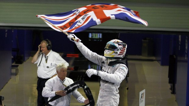Lewis Hamilton waves the Union flag after winning the Abu Dhabi Grand Prix to claim the F1 title.
