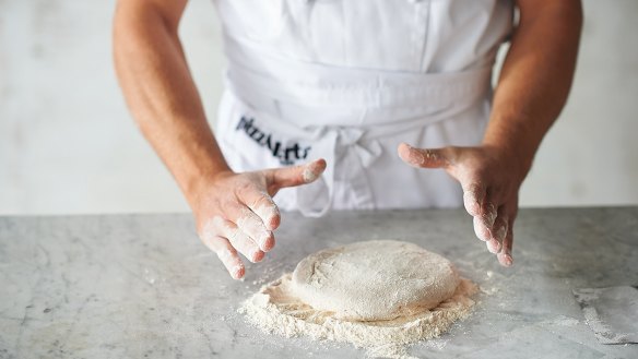 Shaping the base step 4: Place the dough ball, still bottom side up, on a small mound of flour and turn it over in the flour so that both sides are covered.