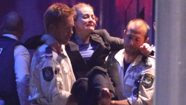 Police Rescue officers carry injured hostage Marcia Mikhael out of the Lindt Cafe.