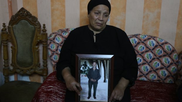 Fayza Makeen holds a portrait of her hiusband Magdy Makeen, who died in police custody, at their home in the Cairo district of al-Zawiya al-Hamra. 