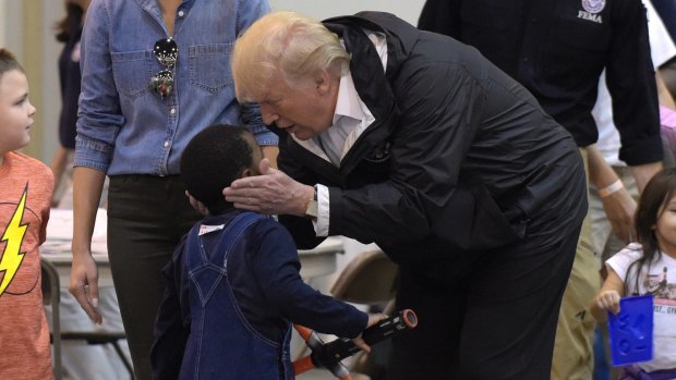 President Donald Trump talks to a little boy who is homeless after the storm.