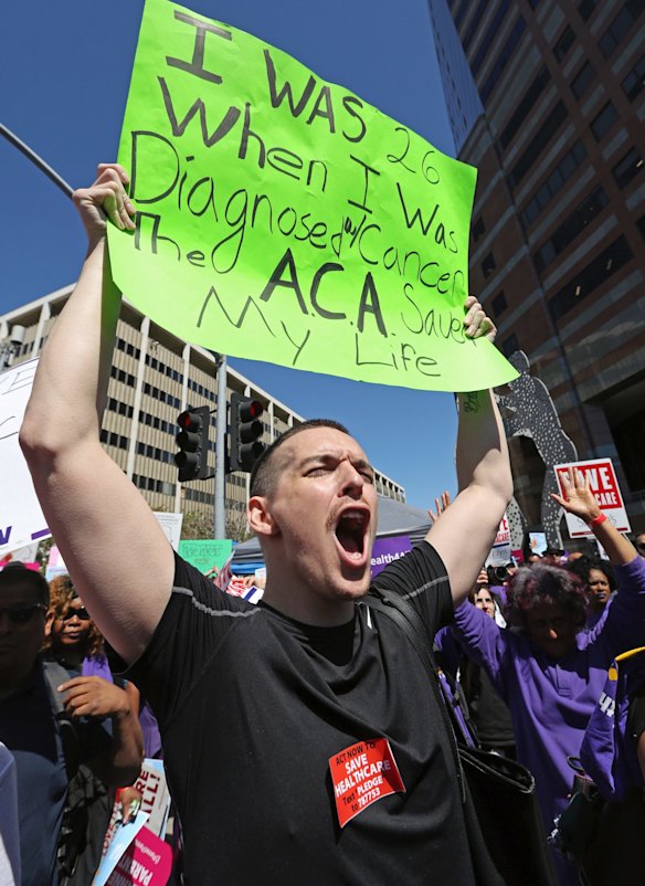 Steven Martin, 27, of Los Angeles, who says he has chronic myeloid leukemia, joins hundreds of people march through downtown Los Angeles on Thursday.