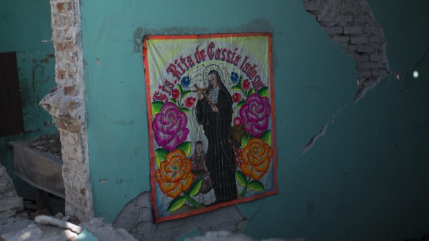 A picture of a saint hangs inside a collapsed home following an earthquake in the town of Asuncion Ixtaltepec, Oaxaca State, Mexico.
