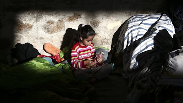 A girl plays inside a temporary shelter for refugees and migrants at the Athens' port of Piraeus.