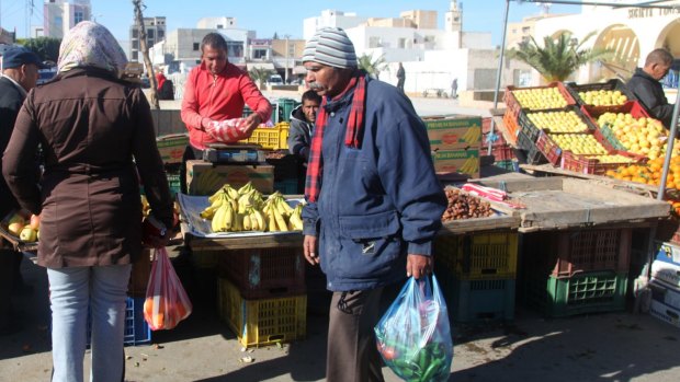 Mohamed Bouazizi's cousin Abdessalam, 31, in red, still works as an irregular street vendor in the city of Sidi Bouzid.