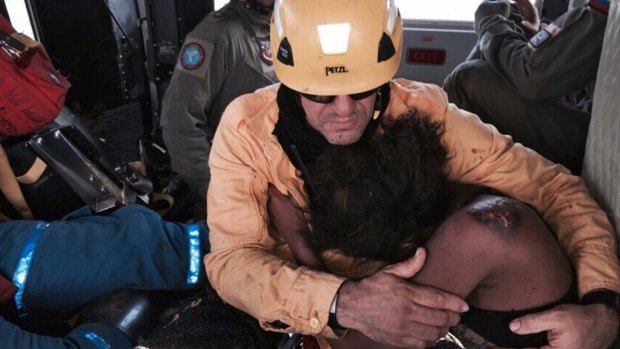 Nelly Murillo clings to a rescuer after spending days in the jungle with her young child. 