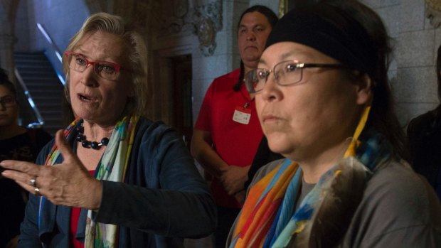 Surrounded by Marcia Brown Martel and "Sixties Scoop" survivors, Indigenous Relations Minister Carolyn Bennett responds to a question during a news conference on Parliament Hill, in Ottawa, Canada.