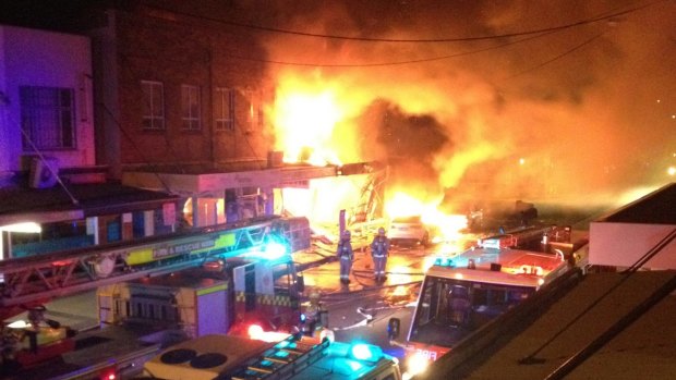 The fire destroys shops and apartments on Darling Street.