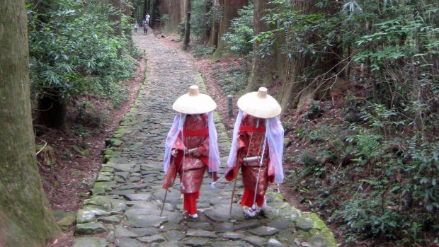 Pilgrims dressed in traditional clothing climb Daimon-zaka Slope along the Kumano Kodo, Japan. 