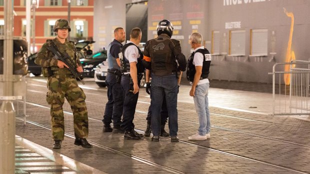 Police officers and a soldier stand by the sealed-off area where the attack took place.