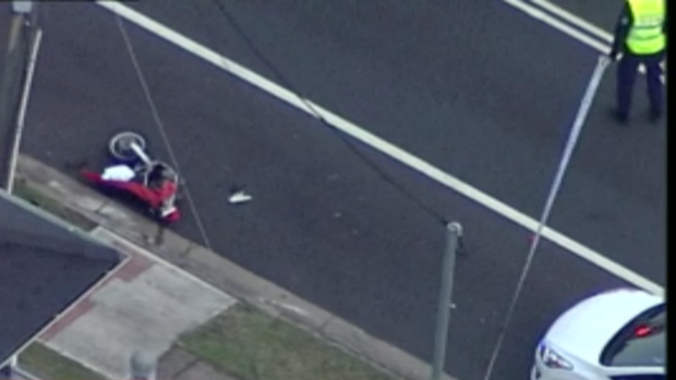 A damaged trail bike is left on the side of the road after an accident and police pursuit.