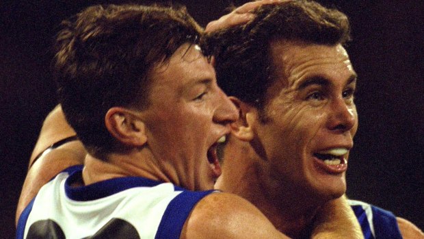 A young Brent Harvey and his captain Wayne Carey embrace during a final in 2000.