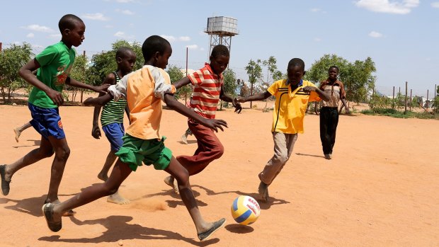 Boys play soccer inside a refugee camp. Soccer unites people across the world, Victorian Premier Daniel Andrews says. 