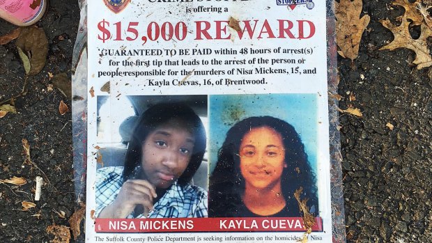 A poster featuring photos of Nisa Mickens and Kayla Cueva is part of a memorial near the spot where their bodies were found in Brentwood.