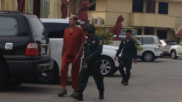 Australian James Ricketson is escorted into a Phnom Penh court on Wednesday.