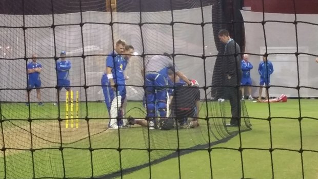 Shaken: Australia players and staff surround Tom Cotter-Gilles after he was struck on the head by a ball hit by all-rounder Mitch Marsh during a training session under floodlights at the Adelaide Oval. 