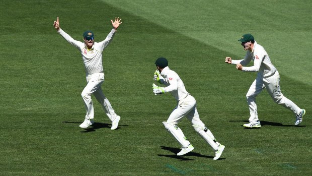 Victory march: Steve Smith, Tim Paine and Peter Handscomb celebrate the final wicket.