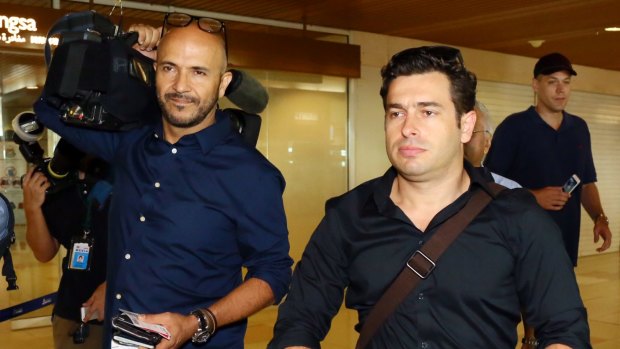 Reporter Linton Besser, right, and camera operator Louie Eroglu prepare to leave at Kuching International Airport.