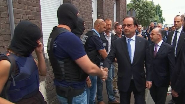 French President Francois Hollande shakes hands with police and security personnel in Normandy.