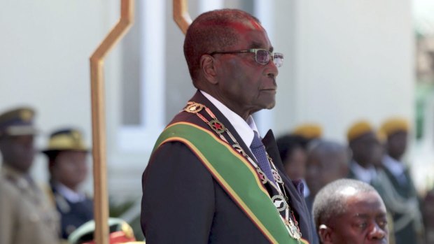 Zimbabwe President Robert Mugabe stands as the national anthem is being played before officially opening parliament in Harare, Zimbabwe.
