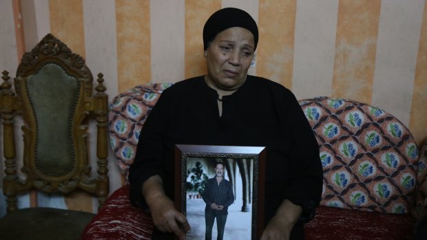 Fayza Makeen holds a portrait of her husband Magdy Makeen, who died in police custody, at their home in the Cairo district of al-Zawiya al-Hamra. 