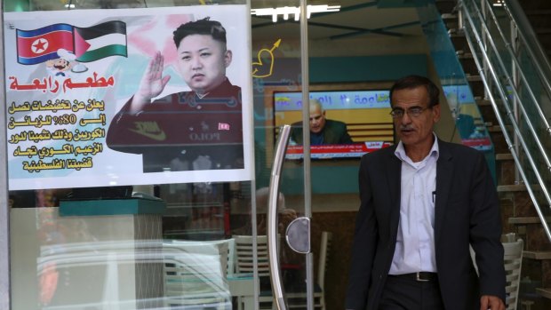 A Palestinian customer walks out of a shawarma restaurant with a poster of North Korean leader Jim Jong at the entrance of it in Jebaliya refugee camp, Gaza Strip.