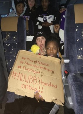 Team huddle: The Niagara University women's basketball team team hold a sign while their bus was stuck in snow in the State of New York.
