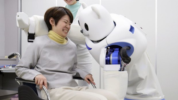 Robear lifts a woman into a wheelchair during a demonstration in Nagoya, Japan. 