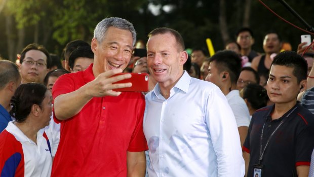 Time for a selfie ... Tony Abbott, right, with Singapore Prime Minister Lee Hsien Loong attend the '50 BBQ' event at Bishan Park, Singapore. 