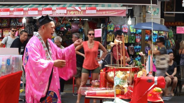 A man conducts Hungry Ghost Festival prayers in Singapore's Chinatown.