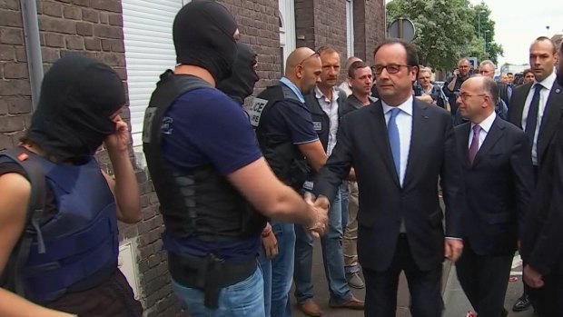 French President Francois Hollande shakes hands with police and security personnel in Normandy, France.
