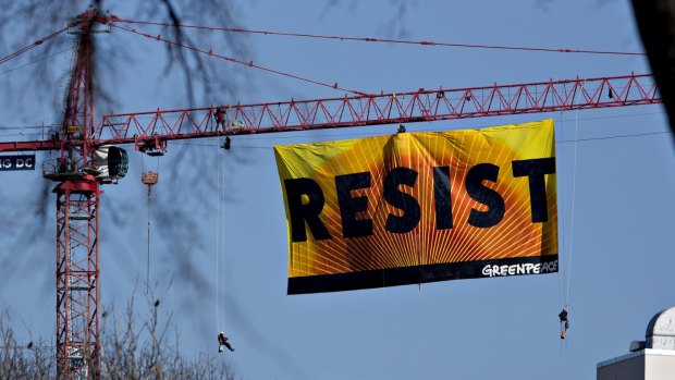 The banner with activists dangling from the side.
