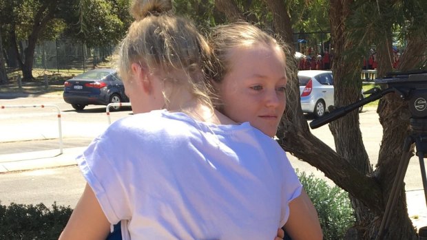 Lexie hugging her twin sister after being found in bushland a three hour's walk from her home. 