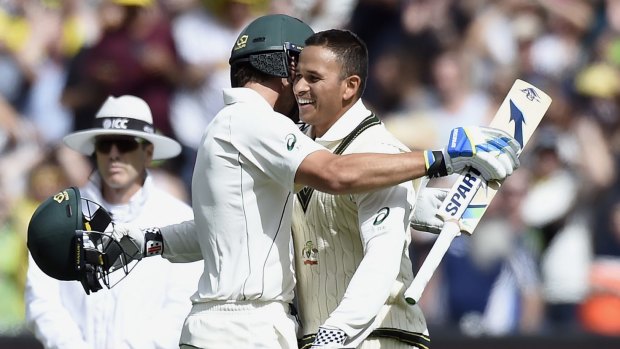 Big stand: Usman Khawaja and Joe Burns embrace after they both notched their centuries just a couple of minutes apart.
