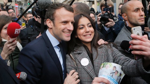 Independent centrist presidential candidate Emmanuel Macron poses for a selfie after visiting a police station in Paris. 