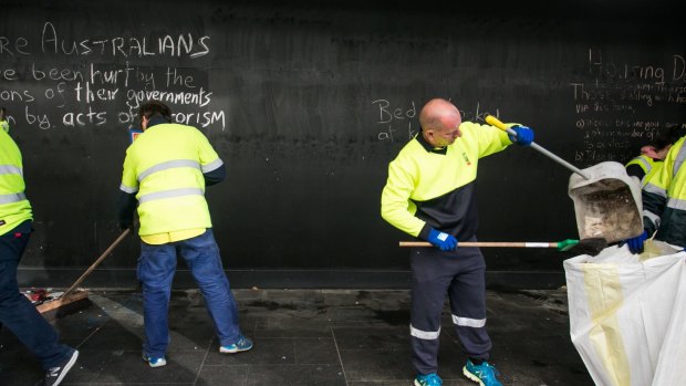 Council staff remove items left by the homeless in Martin Place.
