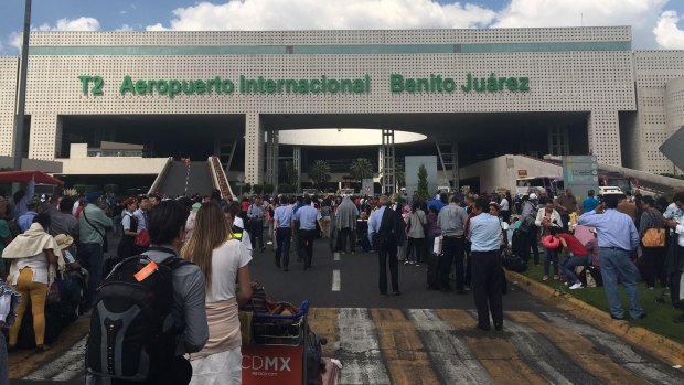 Travellers evacuate Mexico city airport following the earthquake.