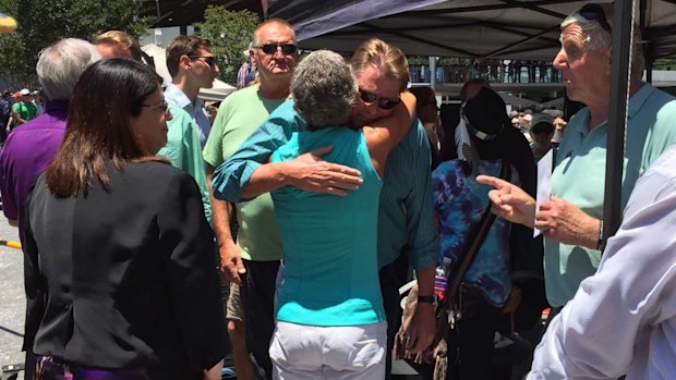 Well-wishers greet Cole Miller's father Steve at the a memorial.