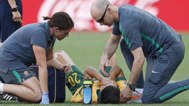 Sam Kerr receives treatement on the pitch.