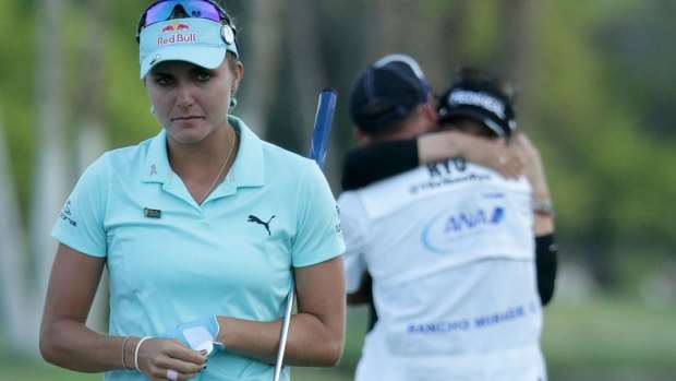 Lexi Thompson (L) walks off the 18th green as So Yeon Ryu of South Korea celebrates with her caddie.