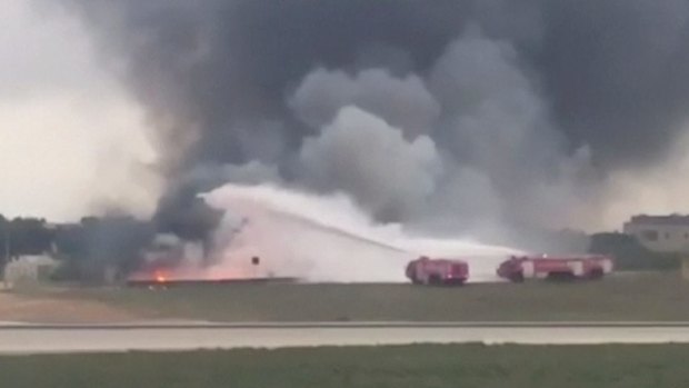 Fire engines attempt to extinguish a fire after the plane crashed at Malta International Airport.