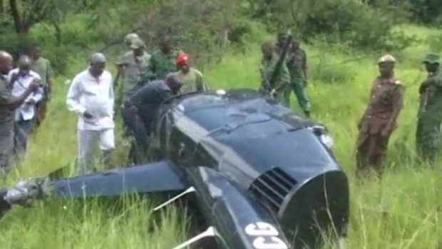 In an image taken from local television footage, Jumanne Maghembe, Tanzania's Minister for Tourism and Natural Resources, and officials walking towards helicopter wreckage at the site where a British pilot was killed after his helicopter was fired on by elephant poachers in Tanzania on Saturday. 