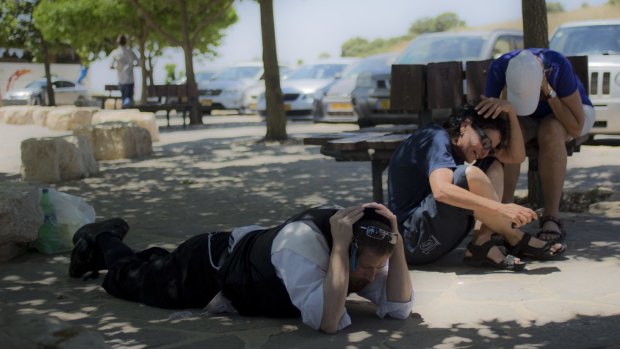 Israelis take cover as a siren warns of incoming rockets in Golan Heights.