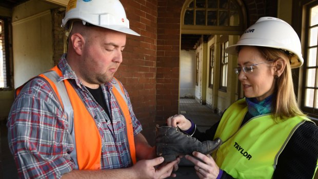 Archaeologist David Marcus and NSW Attorney-General Gabrielle Upton examine the boot at the old Children's Court.