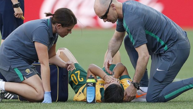 Sam Kerr receives treatement on the pitch.