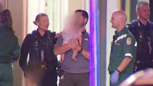 A child is comforted by police after a dramatic stand-off with a man in Adelaide.