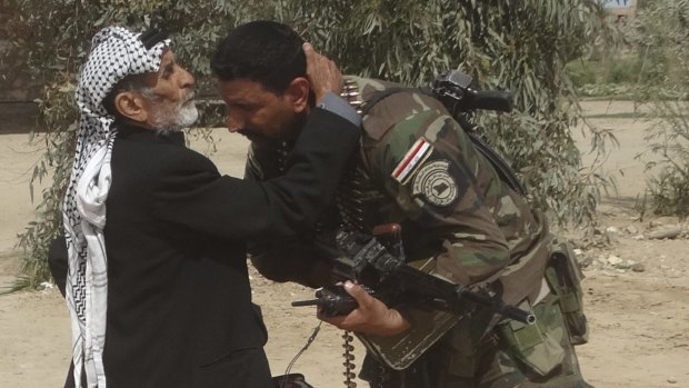 Thank you: A man kisses an Iraqi soldier after security forces pushed out Islamic State terrorists from villages outside Ramadi, Iraq, on Wednesday.
