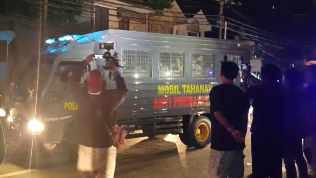 Indonesia police transfer prisoners from  Kerobokan jail in December 2015. On the side of the police bus it says "prisoner car - anti-thuggery".
